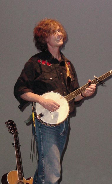 Dave Carter smiling, playing a banjo.